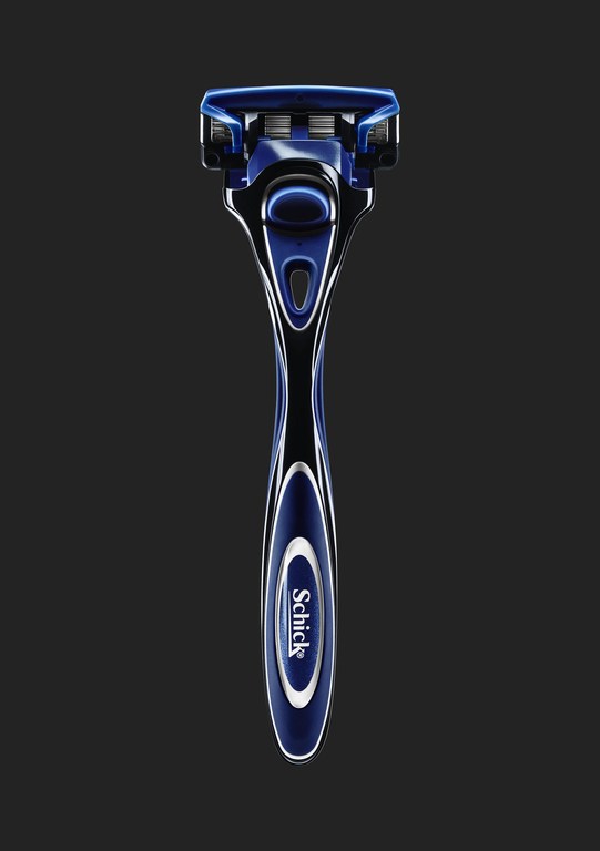 Close-up studio shot of a blue and black Schick razor against a dark background, highlighting the razor's design and features.