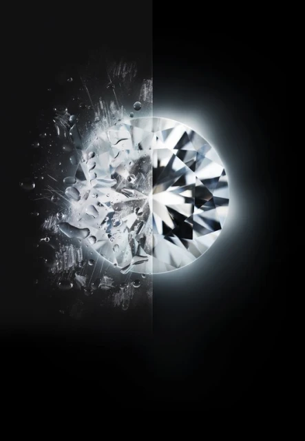 Close-up of a round cut diamond, half with water droplets and scratches, half clean and illuminated on a black background.