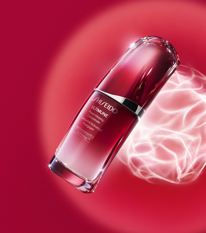 Shiseido Ultimune Power Infusing Concentrate on a red background with white light effects, showcasing its beauty and skincare qualities.