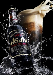 Asahi beer bottle and overflowing glass surrounded by splashing water on a dark background