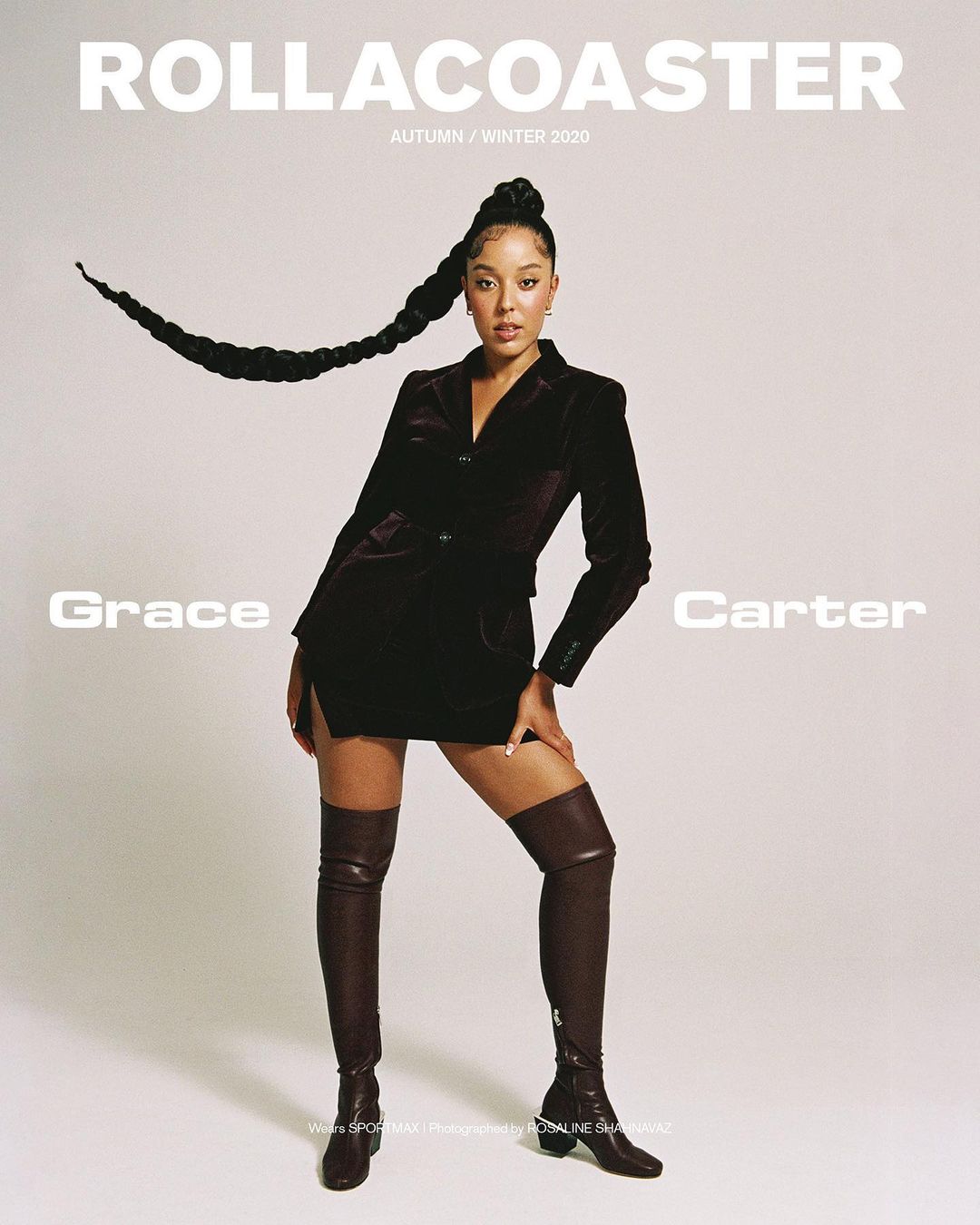 Grace Carter poses in a dark velvet blazer dress and thigh-high boots, hair in a long braid, for a magazine cover shoot.