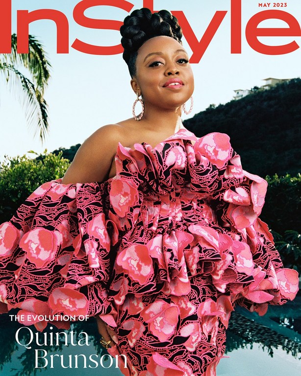 Magazine cover featuring Quinta Brunson in a large pink floral dress, posing outdoors against a blurred background of trees and water.