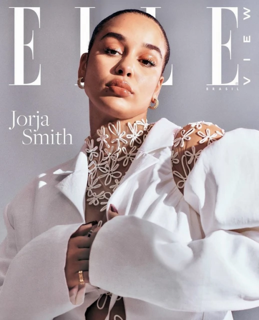 Elle Brazil cover featuring Jorja Smith, wearing a white blazer and floral appliqué top, against a soft grey studio backdrop. 