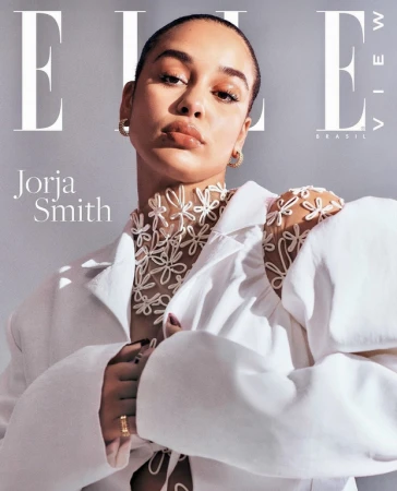 Elle Brazil cover featuring Jorja Smith, wearing a white blazer and floral appliqué top, against a soft grey studio backdrop. 