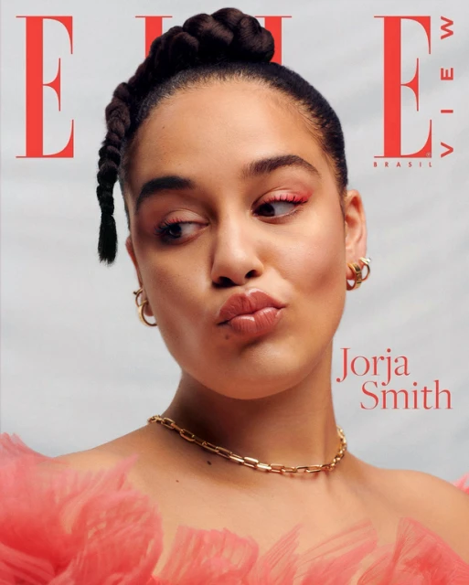 Elle Brasil cover featuring a portrait of Jorja Smith with braided hair looking to the side with a playful expression and pink ruffles.