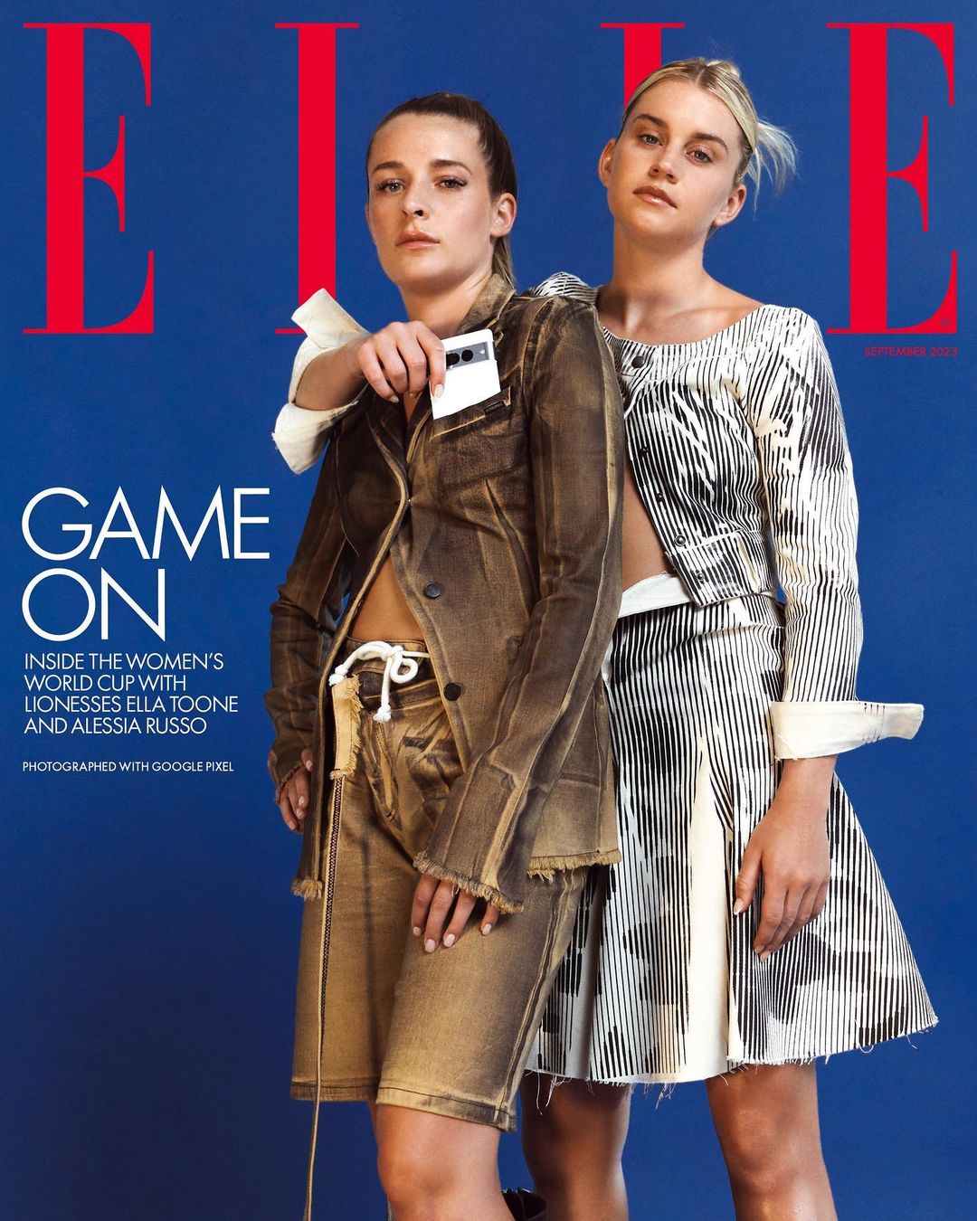 Elle magazine cover featuring two female models in stylish outfits against a blue backdrop. The focus is on fashion and portraiture.