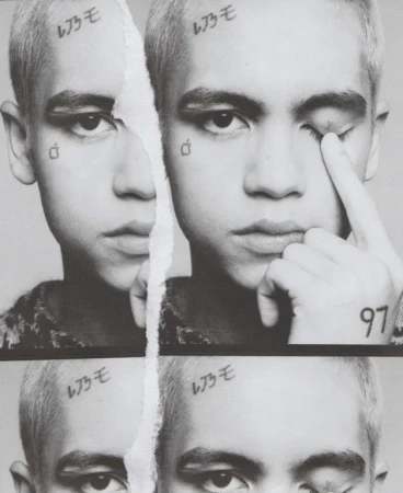 Monochromatic portrait of a young adult with face tattoos split by a torn paper effect, showcasing a pensive and raw aesthetic.