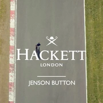 Overhead shot on a racetrack features a male figure on a bicycle, branded Hackett London logo and Jenson Button text.