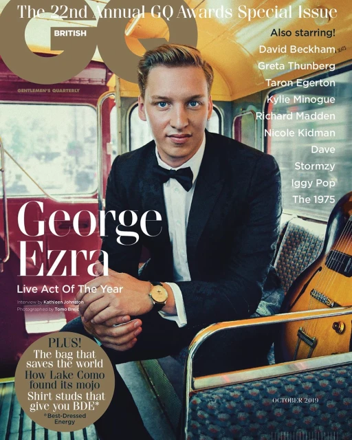 GQ Magazine cover featuring George Ezra in a suit and bow tie, indoors with a guitar and subway car background, October 2019 issue.