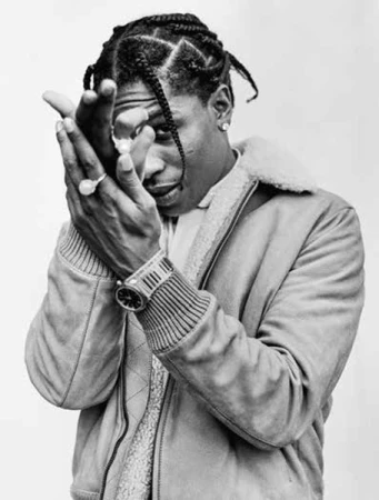 Portrait of ASAP Rocky wearing a shearling bomber jacket and rings, photographed in black and white by Tomo Brejc.