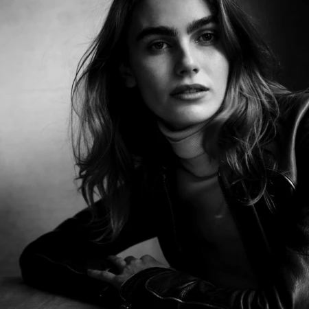 Monochrome portrait of a woman wearing a dark leather jacket and turtleneck, photographed by Victor Demarchelier.