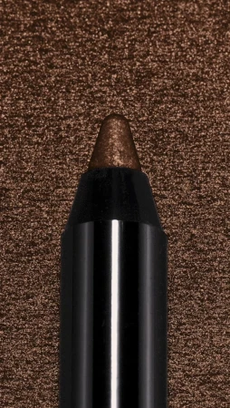 Close-up of a brown eyeliner pencil with a black casing, positioned against a textured brown background. Beauty product detail.
