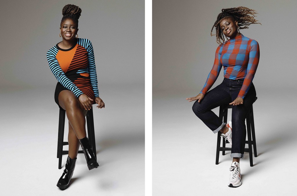 Two Black women seated on stools in a photo studio. One wears a striped dress and patent boots, the other a checkered top and jeans.