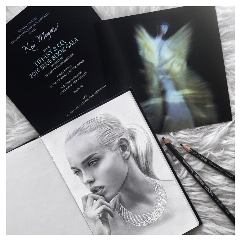 Pencil drawing of a woman with jewelry, Tiffany & Co. gala invitation, and pencils arranged on a white fur-like surface.