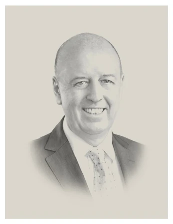Portrait of a smiling, bald adult man in a suit and tie against a neutral background. The portrait is rendered in a monochrome style.