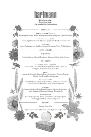 Elegant grayscale menu featuring appetizers, salads, main courses, and desserts, adorned with floral elements and vintage travel props.