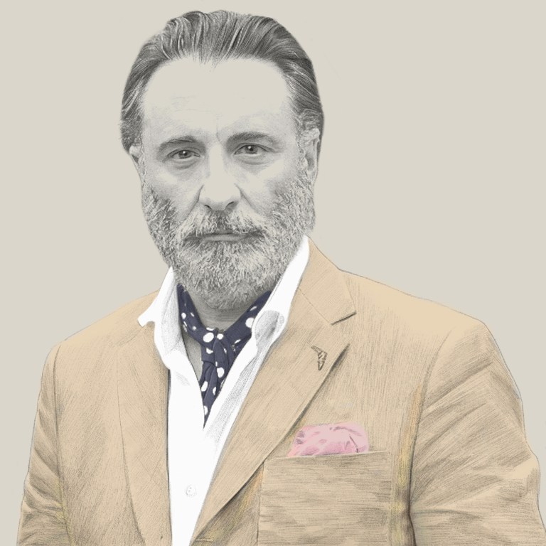 Illustration of mature man in suit jacket, polka dot ascot, and pocket square, grey beard, and silver hair, looking at the camera.