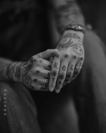 Close-up monochrome portrait of tattooed hands clasped together, photographed by Allie and Jesse.