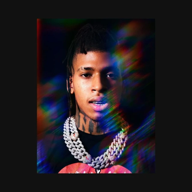 Close-up of a young adult with braided hair, wearing a diamond chain necklace, against a black background with prismatic lighting.