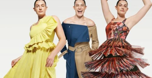 Three female models posing against a white background, wearing vibrant yellow, blue, and patterned dresses.