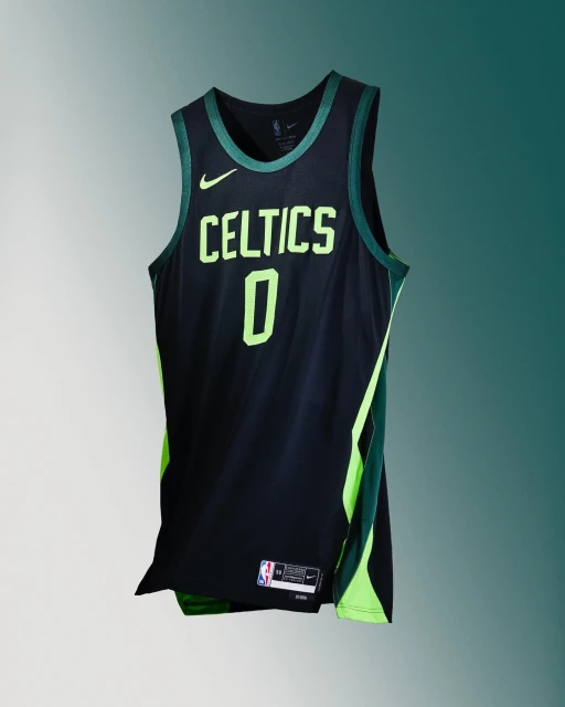 Boston Celtics black and green basketball jersey, number 0, hanging against a gradient teal background in a studio product shot.