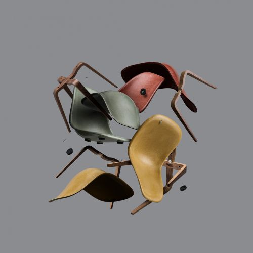 Collection of mid-century modern molded plastic shell chairs with wood legs in red, yellow, and green arranged in a levitating heap.