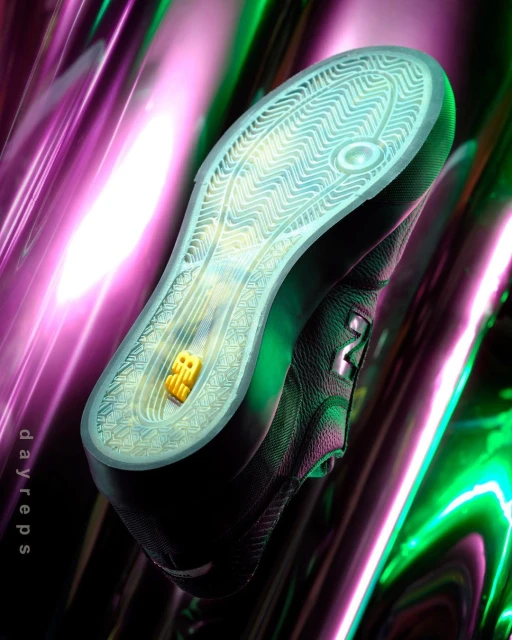 Studio shot of a black New Balance sneaker showing the outsole with a logo on an abstract purple and green background.