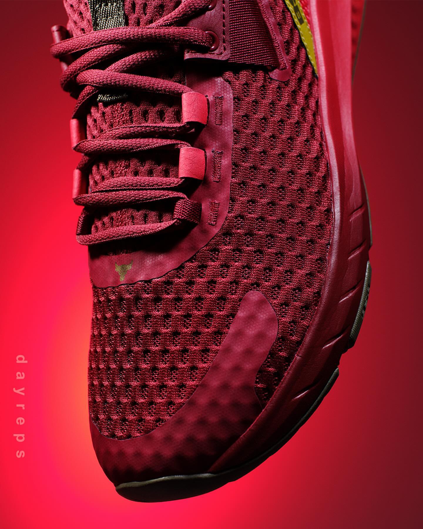 Close-up studio shot of a red athletic shoe featuring a woven texture, visible laces, and a red and yellow brand logo.