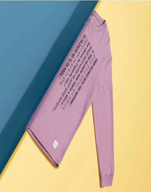 Long sleeved shirt with text in multiple languages on blue and yellow background. Top clothing apparel product flat lay.