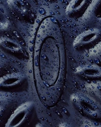 Macro shot of dark textured surface with oval logo and water droplets by Brian Kelley