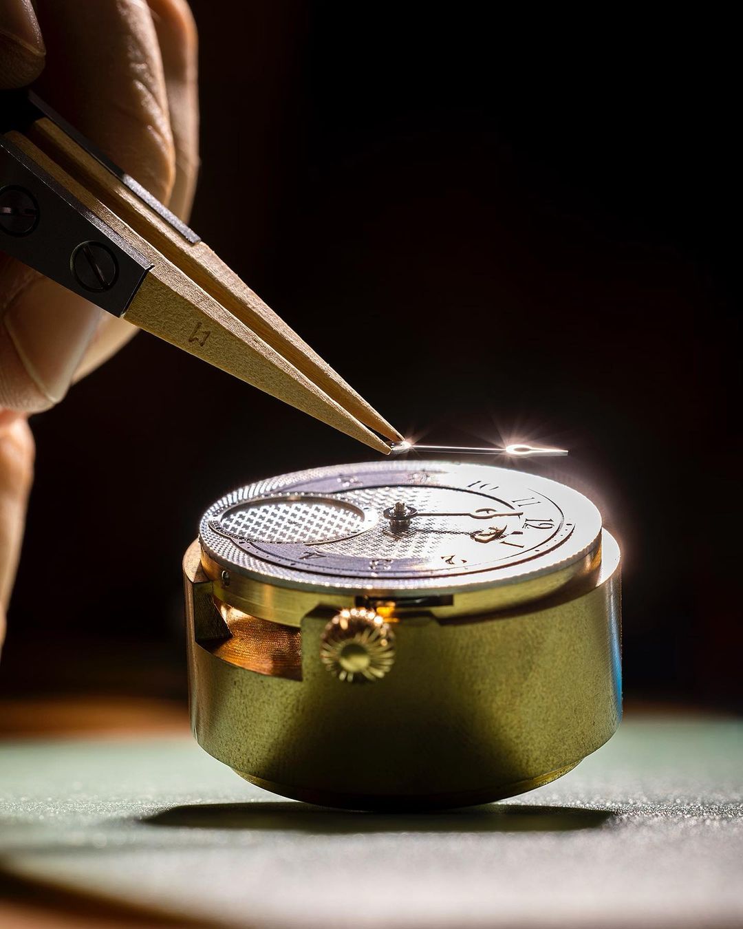 Close-up of a watchmaker using tweezers to assemble a watch, highlighting precision, craftsmanship, and attention to detail in watchmaking.