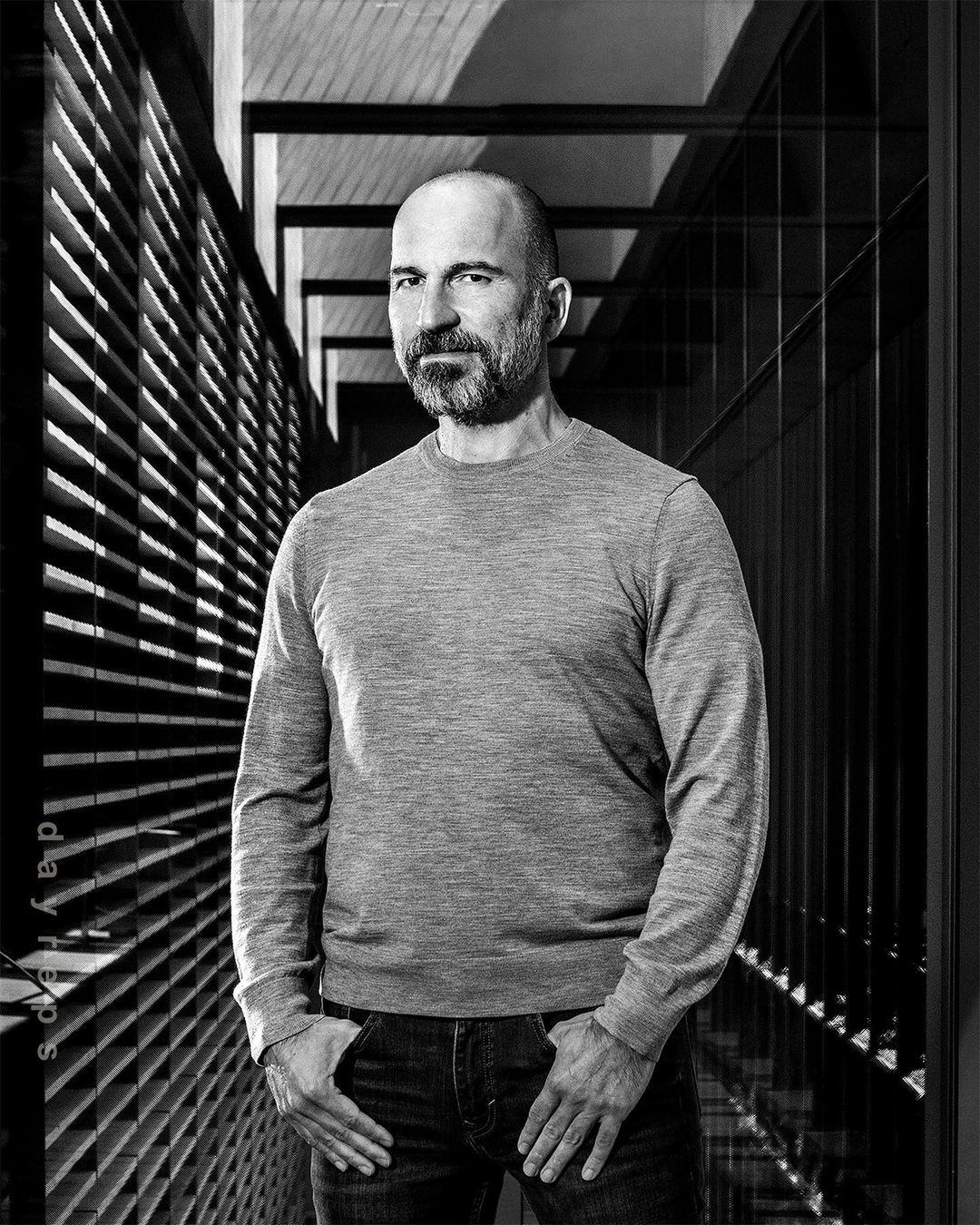 Portrait of a man with a beard wearing a grey sweater standing in a hallway by Christie Hemm Klok