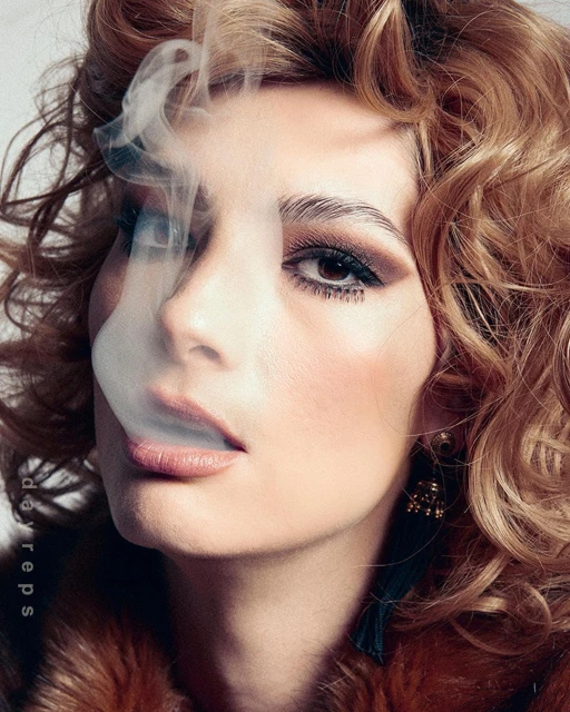 Glamorous adult woman in fur coat with curled hair posing with smoke against a light background, styled with statement earrings.