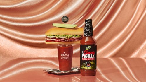 Still life of sandwich and Bloody Mary mix, featuring Jimmy's Famous Bloody Mary Pickle Mix and Mama Approved branding in a studio.