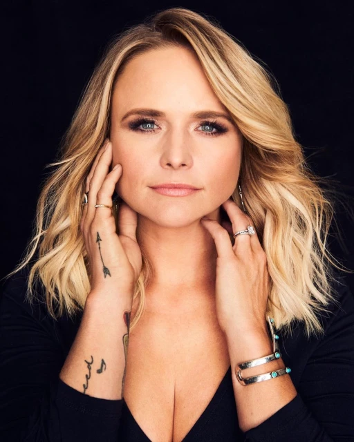 Close-up studio portrait of Miranda Lambert, a blonde woman with fair skin, wearing a black top and turquoise jewelry, looking at camera.