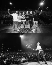 Black and white concert photography by John Shearer featuring a band posing on stage before a massive crowd at night.