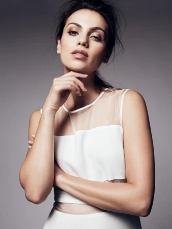 Portrait of a woman with dark hair wearing a white sleeveless top resting her chin on her hand against a grey background
