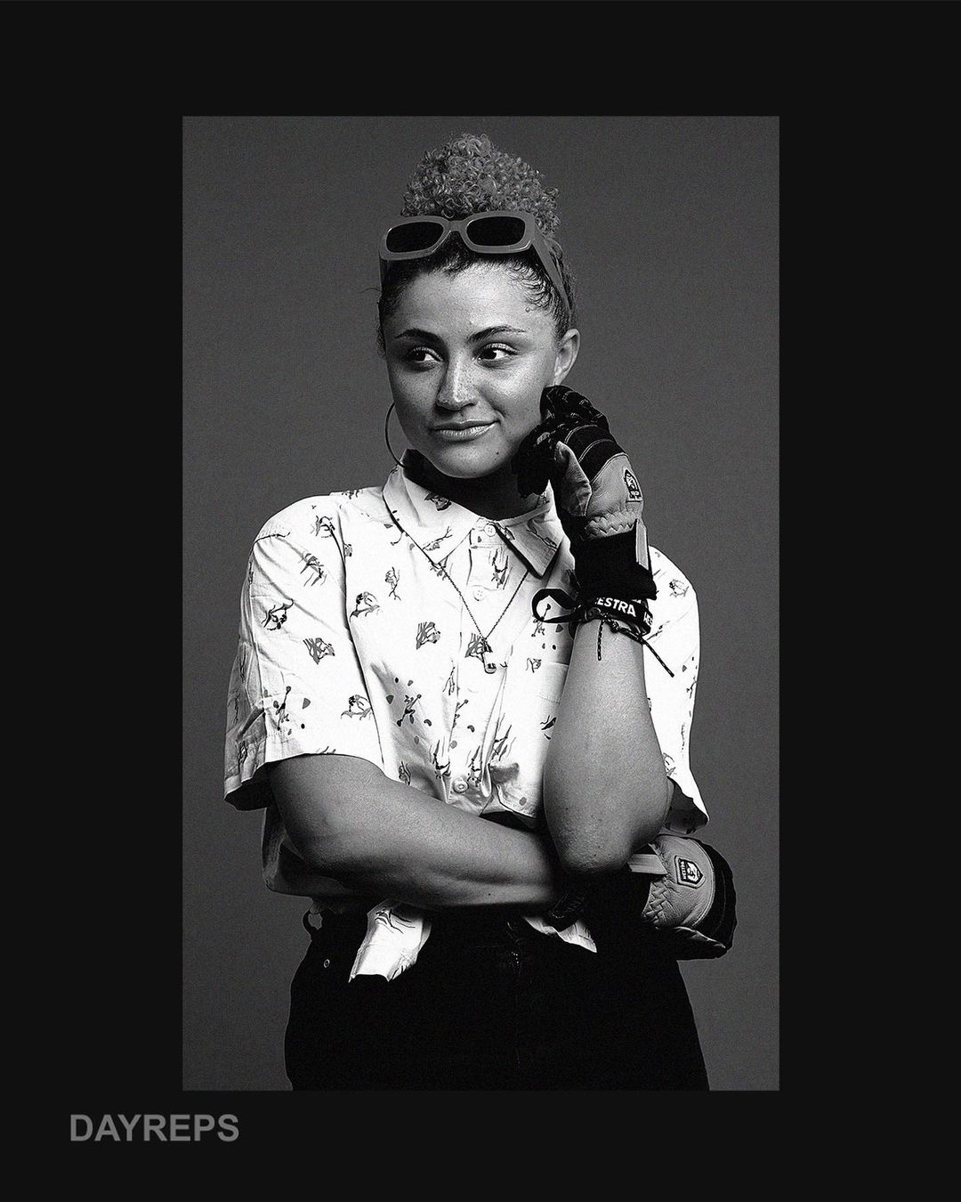 Portrait of a woman wearing patterned short-sleeve shirt and sunglasses on her head by Kareem Black
