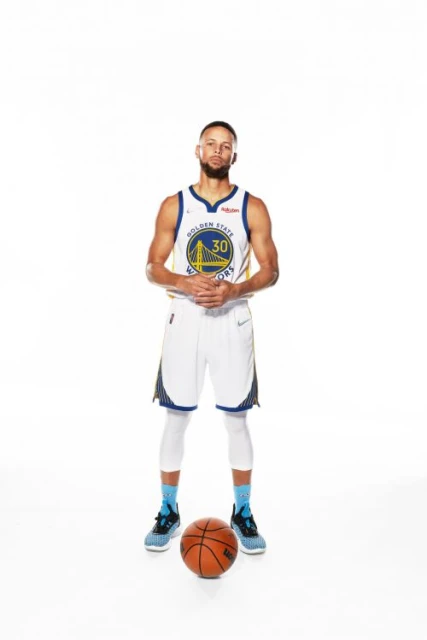 Full shot of an adult male basketball player in uniform with a basketball on a white background, wearing a blue and gold jersey.