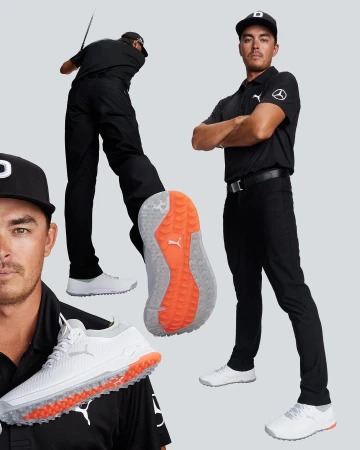 Golf shoes and golf apparel are displayed against a grey backdrop, worn by a light-skinned adult male golfer.
