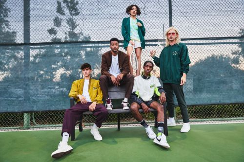Five diverse young adults pose on a bench in a sportswear fashion shot on a tennis court with athletic shoes, shorts, and jackets.