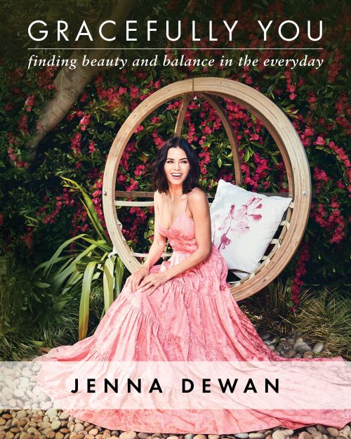 Jenna Dewan sits on a hanging swing chair in a flowing pink dress, promoting her book 'Gracefully You' surrounded by flowers.