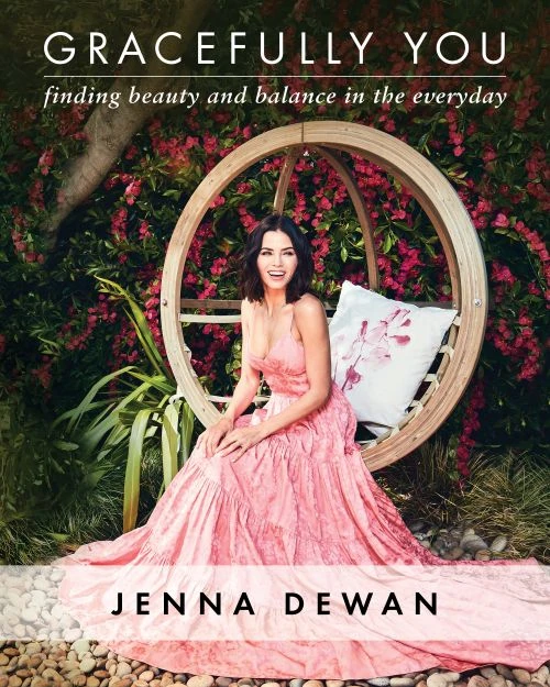 Jenna Dewan sits on a hanging swing chair in a flowing pink dress, promoting her book 'Gracefully You' surrounded by flowers.