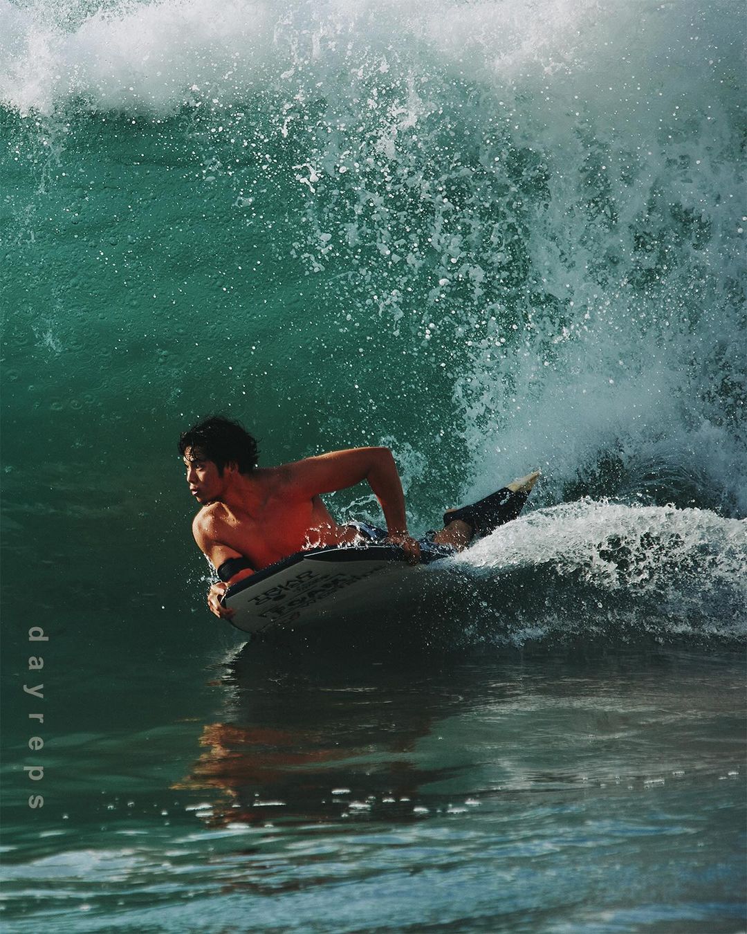 Male bodyboarder riding a wave in the ocean, showcasing the sport of bodyboarding and ocean wave activity.