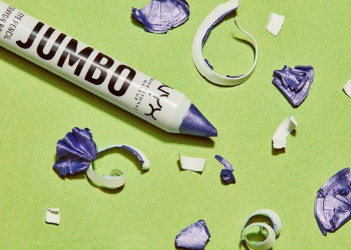 NYX Jumbo eye pencil with shavings on a lime green background in a close-up studio shot showcasing makeup product details.