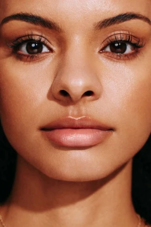 Close-up portrait of a woman with warm glowing skin and natural makeup photographed by Katie Thompson