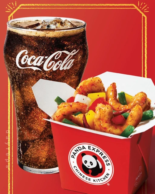 Close-up of a glass of Coca-Cola next to a red cardboard container of Panda Express shrimp and mixed vegetables on a red background.
