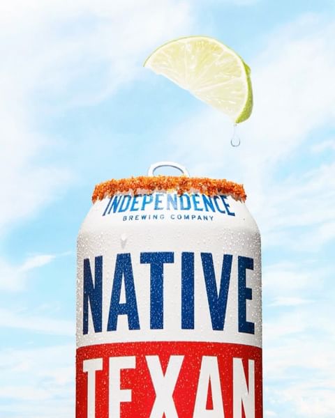 Refreshing beer can with a slice of lime against a cloudy sky, ideal for summer refreshment and beverage promotions.