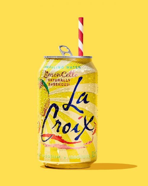 La Croix LimonCello can with red and white striped straw against a solid yellow background in a studio setting.