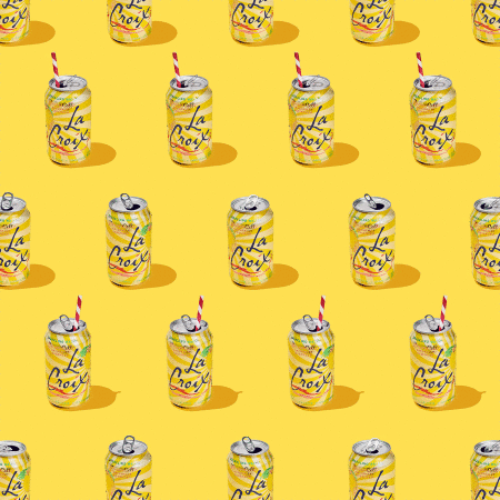 Sparkling water cans arranged in a repeating pattern on a bright yellow background, some with striped straws, under studio lighting.